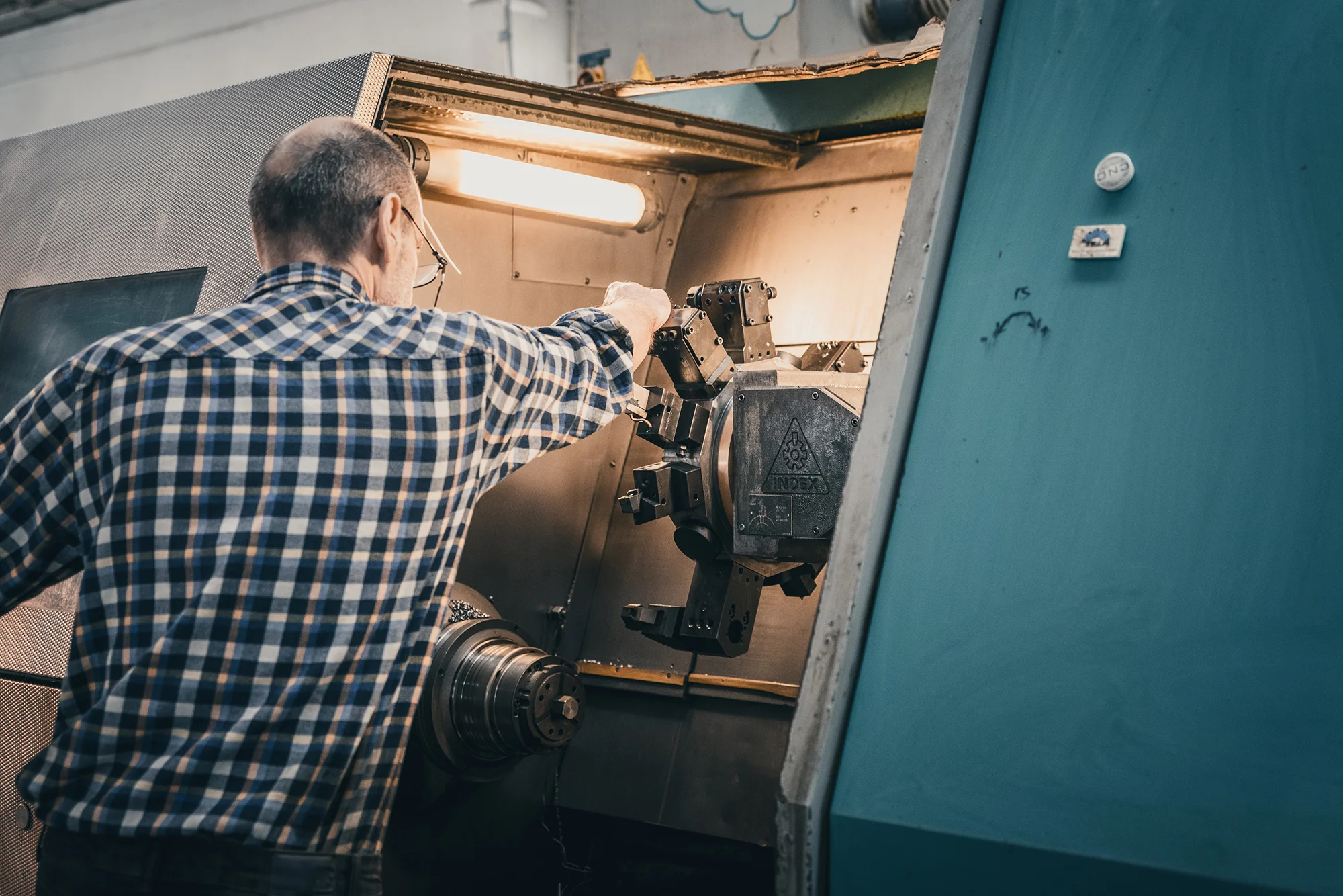 Werbefotografie eines Arbeiters welcher seine Maschine einstellt